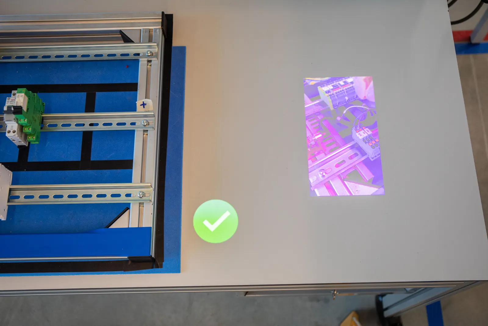 A green check mark is projected after the 3D sensor confirms the step was done correctly
