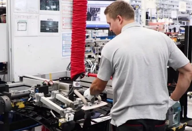 Operator working at a manual assembly station on a production line