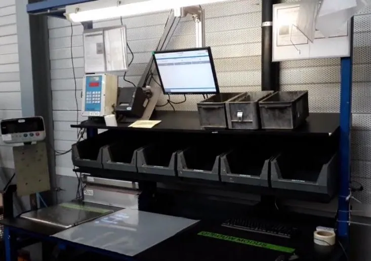 Packing station with picking bins, an operator screen, a label printer and a packing surface