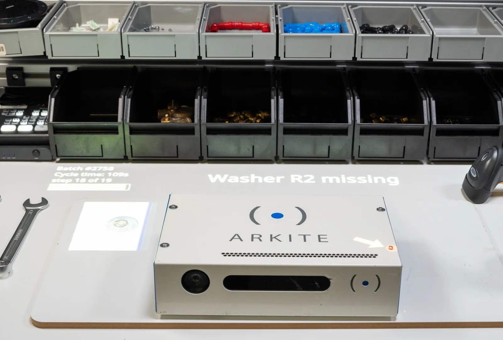Arkite workstation projecting the message Washer R2 missing next to the product, with step progress and cycle time projected on the workbench