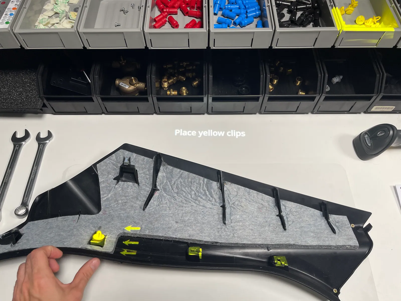 Operator guided by a projected instruction to place yellow clips at highlighted positions