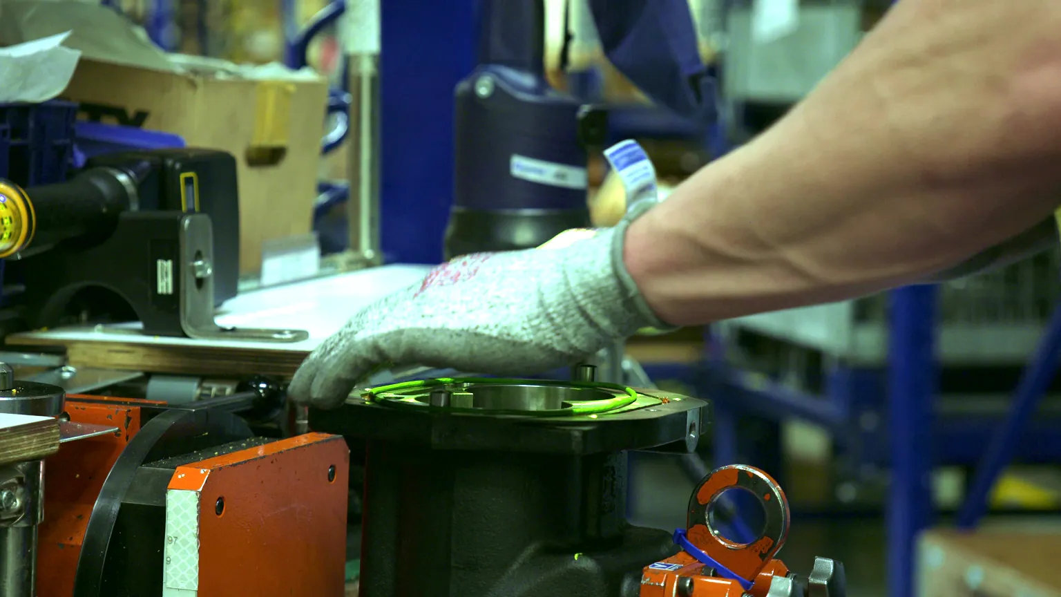 Operator placing a part on an automotive component while a projected outline marks the correct position